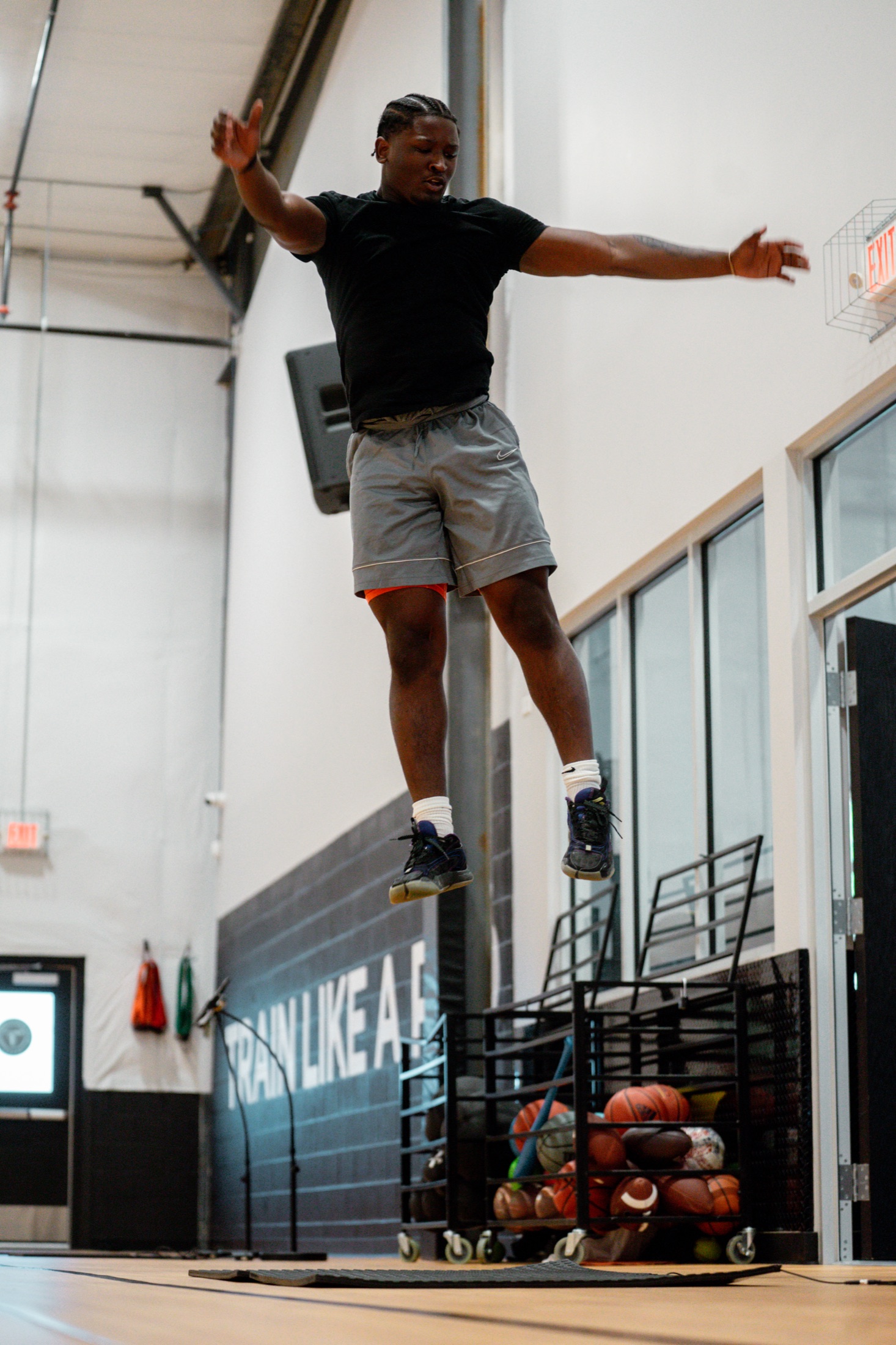 Athlete mid-flight over a Plyomat contact mat
